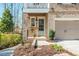 Inviting entrance with a pale blue front door, manicured landscaping, and convenient access to the attached garage at 385 Rowes Cir, Alpharetta, GA 30009