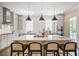 Bright kitchen with quartz countertops, an island with seating, and modern lighting fixtures at 385 Rowes Cir, Alpharetta, GA 30009