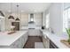 An open kitchen featuring stainless appliances, expansive countertops, a farmhouse sink, and dark hardwood floors at 385 Rowes Cir, Alpharetta, GA 30009