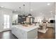 Open-concept kitchen featuring a large island with pendant lighting and stainless steel appliances at 385 Rowes Cir, Alpharetta, GA 30009