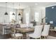 Open-concept kitchen featuring white cabinets, a kitchen island, and modern pendant lighting at 385 Rowes Cir, Alpharetta, GA 30009