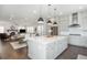 Open-concept kitchen and living area with modern appliances and a fireplace in the background at 385 Rowes Cir, Alpharetta, GA 30009