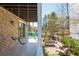 Covered porch with swing, seating, and views of the outdoor living space at 385 Rowes Cir, Alpharetta, GA 30009