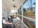 Inviting screened-in porch featuring stylish outdoor seating, ceiling fan, and views at 385 Rowes Cir, Alpharetta, GA 30009