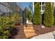 Stone steps lead to a landscaped backyard with manicured landscaping and black fence at 385 Rowes Cir, Alpharetta, GA 30009