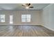 Spacious living room features hardwood flooring, a ceiling fan, and natural light from large windows at 4594 Eastbrook Pl, Snellville, GA 30039