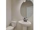 Powder room featuring a pedestal sink, oval mirror, and toilet at 4594 Eastbrook Pl, Snellville, GA 30039