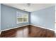 This bedroom features hardwood floors, blue painted walls, and a large window at 1761 Brandemere Dr, Austell, GA 30168