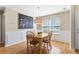 Cozy dining room boasts wainscoting detail, a modern light fixture, and a bright window at 300 W Oaks Trl, Woodstock, GA 30188