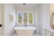 A soaking tub beneath a window offering a view of the trees is the focal point of this bright bathroom at 479 Argonne Nw Dr, Atlanta, GA 30305