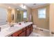 Bright bathroom featuring double sinks, tiled floor, and a large mirror with ample lighting at 2208 Clarendon Ne Ct, Conyers, GA 30012