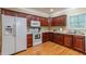 Charming kitchen featuring wooden cabinets, white appliances, and hardwood floors offering a cozy cooking experience at 2208 Clarendon Ne Ct, Conyers, GA 30012