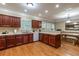 Open-concept kitchen with wooden cabinets, white appliances, and breakfast bar seamlessly connected to dining area at 2208 Clarendon Ne Ct, Conyers, GA 30012