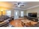 Bright living room with hardwood floors, crown molding, ceiling fan and modern furniture at 2208 Clarendon Ne Ct, Conyers, GA 30012