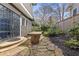 Serene backyard with lush greenery, a stone patio, a wooden bench, and mature landscaping at 289 9Th Ne St, Atlanta, GA 30309