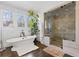 Bright bathroom featuring a freestanding tub, a glass enclosed shower, and natural light from large windows at 289 9Th Ne St, Atlanta, GA 30309