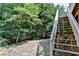 Backyard view showing steps leading to a tranquil landscaped area with wooded surroundings at 4260 River Club Dr, Cumming, GA 30041