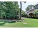 Spacious backyard with a large tree, wooded perimeter, and deck with stairs for outdoor enjoyment at 4260 River Club Dr, Cumming, GA 30041