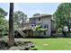 View of the home's back exterior featuring a deck, stairs, and well-maintained landscaping at 4260 River Club Dr, Cumming, GA 30041