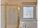 Bathroom with shower, bathtub, and natural light with a unique decorative window at 4260 River Club Dr, Cumming, GA 30041