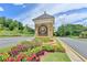 Inviting community entrance with a stone sign, colorful flowers, and manicured landscaping at 4260 River Club Dr, Cumming, GA 30041