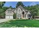 Charming two-story home with a manicured front lawn, two-car garage, and decorative shutters at 4260 River Club Dr, Cumming, GA 30041