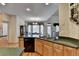 Open kitchen with hardwood floors, granite countertops, stainless steel sink and black appliances at 4260 River Club Dr, Cumming, GA 30041
