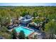 Aerial view of a community pool with a building next to it surrounded by trees and lounge chairs at 4260 River Club Dr, Cumming, GA 30041