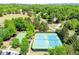 Aerial view of tennis and basketball courts, along with a green grassy area, parking, and lush trees at 4260 River Club Dr, Cumming, GA 30041