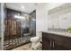 Modern bathroom featuring a glass-enclosed shower, decorative floor tiles, and granite vanity at 2711 Mcdonough Rd, Hampton, GA 30228