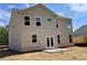 Back exterior of home with beige siding, patio, and a level grassy backyard at 3387 Wild Clary Court Lot 20, Buford, GA 30519
