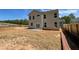Exterior back of the home with a patio area surrounded by a large, unfinished backyard at 3387 Wild Clary Court Lot 20, Buford, GA 30519