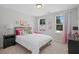 Cozy bedroom featuring a plush bed with colorful pillows and a bright window at 3387 Wild Clary Court Lot 20, Buford, GA 30519