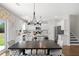 Bright, open-concept kitchen and dining area with white cabinets, stainless appliances, and a large dining table at 3387 Wild Clary Court Lot 20, Buford, GA 30519