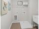 Practical laundry room with tiled floor, utility sink, and ample space for chores at 3387 Wild Clary Court Lot 20, Buford, GA 30519