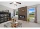 Bright living room with fireplace and backyard view through large windows, creating a warm and inviting space at 3387 Wild Clary Court Lot 20, Buford, GA 30519