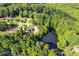 Aerial view of a pond near a residential neighborhood with houses nestled among the trees in a green, serene environment at 144 Bobs Sw Dr, Mableton, GA 30126