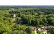 An aerial view of a house surrounded by lush greenery and a tranquil pond, offering a serene and private setting at 144 Bobs Sw Dr, Mableton, GA 30126