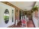 Cozy front porch featuring brick walls, white rocking chairs, and a decorative glass front door at 144 Bobs Sw Dr, Mableton, GA 30126