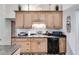 Traditional kitchen with wood cabinetry, a double sink, black appliances and laminate flooring at 144 Bobs Sw Dr, Mableton, GA 30126