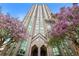 Exterior of a stately building is flanked by blossoming purple trees and bright blue skies at 2870 Pharr Court South Nw # 2402, Atlanta, GA 30305