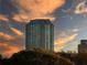 Exterior shot of a high-rise building against a vibrant sunset sky with lush trees in the foreground at 2870 Pharr Court South Nw # 2402, Atlanta, GA 30305