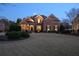 Charming brick home featuring manicured landscaping, symmetrical design, and warm interior lighting at dusk at 359 Flatstone Sw Way, Marietta, GA 30064