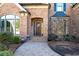 Charming brick home entrance with an arched doorway and brick paver pathway at 359 Flatstone Sw Way, Marietta, GA 30064