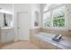 Bright bathroom with large soaking tub and tiled walls with plantation shutters at 359 Flatstone Sw Way, Marietta, GA 30064