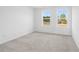 Carpeted bedroom with bright white walls and two windows looking out to nature at 3198 Eastham Run Dr, Dacula, GA 30019