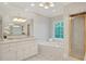 Bathroom featuring double sink vanity, soaking tub, and a glass-enclosed shower at 1139 Tennyson Ne Pl, Brookhaven, GA 30319