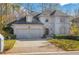 Elegant two-story home featuring a brick driveway, lush lawn, arched windows, and a two-car garage at 1139 Tennyson Ne Pl, Brookhaven, GA 30319