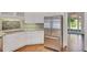 Kitchen boasts stainless steel refrigerator, white cabinetry, and lovely hardwood floors at 1139 Tennyson Ne Pl, Brookhaven, GA 30319
