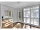 Sun-filled living room featuring hardwood floors, sheer curtains, and views into bonus room at 1139 Tennyson Ne Pl, Brookhaven, GA 30319